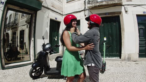 Young-man-helping-his-girlfriend-fixing-motorbike-helmet.